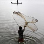 A fisherman casts his fishing net into the waters on a rainy day on the outskirts of Kochi.The regional centre in Thiruvananthapuram put out a weather warning for fishermen and people staying in coastal areas for heavy rains in the next 48 hours.