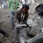 A man carries a body from the rubble of a house destroyed by a Saudi-led air strike in the old quarter of Yemen's capital Sanaa, September 19, 2015.