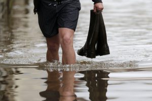 A man holds boots as he walks in a flooded street in Montargis in the Loiret, following heavy rain in France June 1.