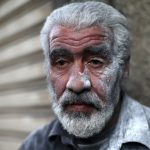 A man is seen covered with flour after unloading flour from a Red Crescent and United Nations aid convoy in the rebel held besieged town of Hamoria area, in the eastern suburbs of Damascus, Syria, on April 19, 2016.