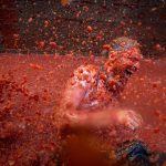 A reveller is pelted with tomato pulp during the annual