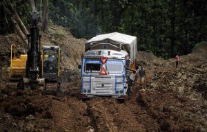 An Indian truck driver makes his way through heavily rutted mud on National Highway 44 (NH-44) at Khasiapunji some 205 kms north of Agartala on the border of the north-eastern states of Assam and Tripura on July 5, 2016.