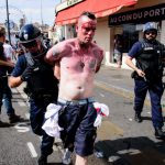 An injured man is arrested following fights between English, Russian and French groups in Marseille, on June 11, 2016, on the sideline of the Euro 2016 European football championships.