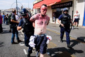 An injured man is arrested following fights between English, Russian and French groups in Marseille, on June 11, 2016, on the sideline of the Euro 2016 European football championships.