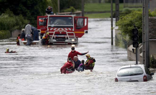 French firefighters on a small boat evacuate residents from a flooded ...