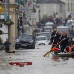French firefighters use a small boat to evacuate residents from a flooded area after heavy rainfall in Nemours, June 1.