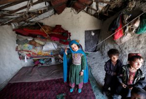 Internally-displaced Afghan children stand inside their shelter at a refugee camp in Kabul, Afghanistan, on May 31, 2016.