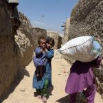 Internally-displaced Afghan children walk at a refugee camp in Kabul on May 31, 2016.