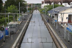 People stand next to flooded railway tracks on June 1, in Souppes-sur-Loing, southeast of Paris.