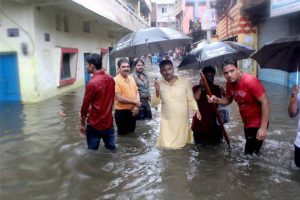 People wade through a flood-affected street in Bhopal on July 10, 2016