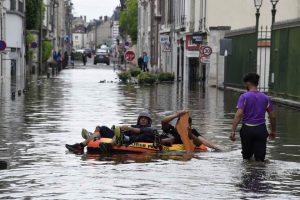 Residents float on an inflatable raft through flooded streets of Montargis, south of Paris, on June 1.