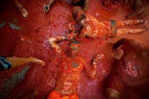 Revellers covered in tomato pulp participate in the annual