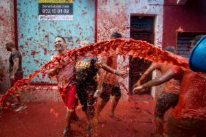 Revellers covered in tomato pulp participate in the annual