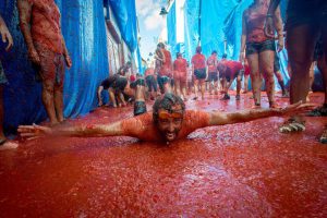 Revellers covered in tomato pulp participate in the annual