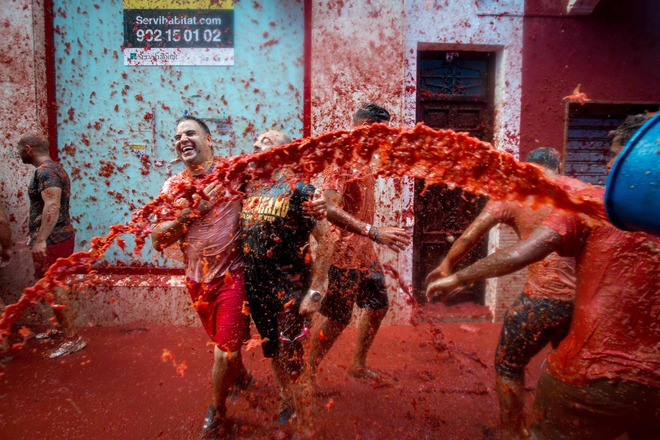 Revellers covered in tomato pulp participate in the annual