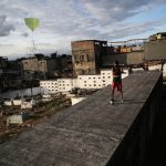 A boy flies his kite in a cemetery in the Vila Operaria Favela of Rio de Janeiro, Brazil.