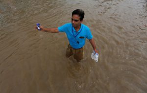 A man directs the vehicles in a waterlogged highway after heavy rains in Gurugram, on the outskirts of New Delhi.