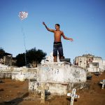 A man flies his kite in a cemetery in the Vila Operaria Favela of Rio de Janeiro, Brazil. Some $12.3 billion has been spent to host South America's first Olympic Games, which kick off on August 5 but for those who live in the slums, there are few public spaces for sports or recreation.