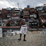 A man flies his kite in a cemetery in the Vila Operaria Favela of Rio de Janeiro, Brazil.