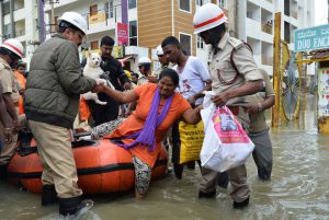 Members of the fire forces and volunteers participate in relief operations in a low-lying flooded area of Bangalore on July 29.