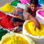 A boy selling colours at a stall waits for customers by a roadside in Gurgaon ahead of Holi