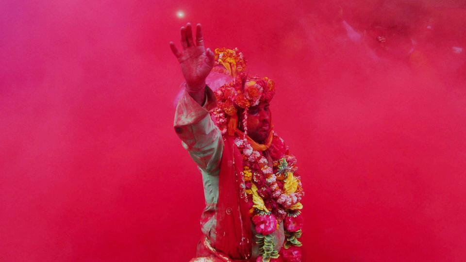 A devotee takes part in rituals on Laddu Holi at Radha Rani temple in Barsana, Uttar Pradesh