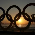 A girl is seen next to the Olympic rings as the sun rises over Fort Copacabana ahead of the Men's Road Race.