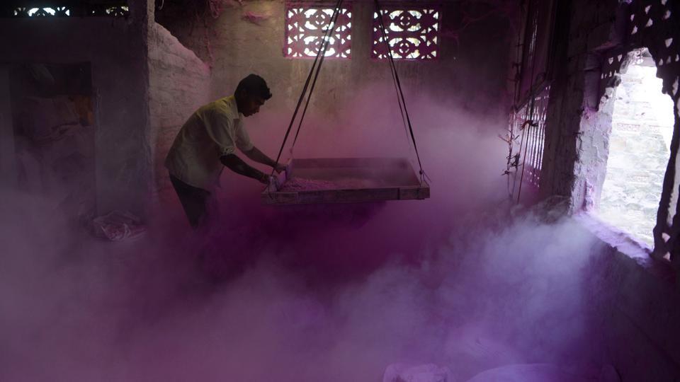 A labourer makes Gulal inside a factory at Fulbari village on the outskirts of Siliguri