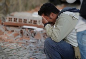 A man reacts after a strong earthquake hit Amatrice, central Italy, on August 24, 2016.
