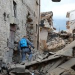 A rescuer searches for victims among damaged buildings after a strong earthquake hit Amatrice on August 24, 2016. Central Italy was struck by a powerful 6.2-magnitude earthquake in the early hours