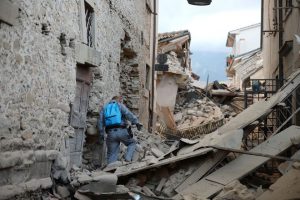 A rescuer searches for victims among damaged buildings after a strong earthquake hit Amatrice on August 24, 2016. Central Italy was struck by a powerful 6.2-magnitude earthquake in the early hours