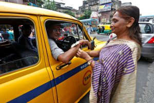 A woman ties Rakhi onto the wrists of a taxi driver during Raksha Bandhan celebrations in Kolkata.