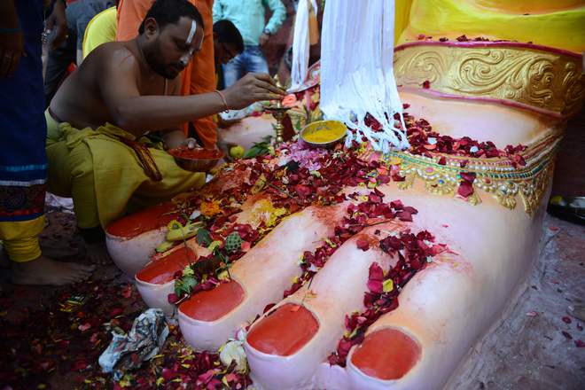 An Indian priest offer prayers at the foot of a 58-foot (17 metre) tall idol of the Hindu god Lord Ganesh, popularly known as ‘Khairatabad Ganesh’, on the Ganesh Chaturthi festival in Hyderabad on September 5, 2016.