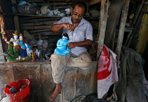 An artisan paints an idol of Lord Krishna at a workshop ahead of Janmashtami in Kolkata.