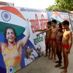 Budding wrestlers in Mokhra, the native village of Olympic medal winner Sakshi Malik, look at her poster in Rohtak on August 23