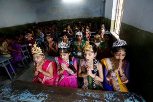 Girls dressed up as Radha pray inside a classroom as they celebrate Janmashtami festival in Ahmedabad.