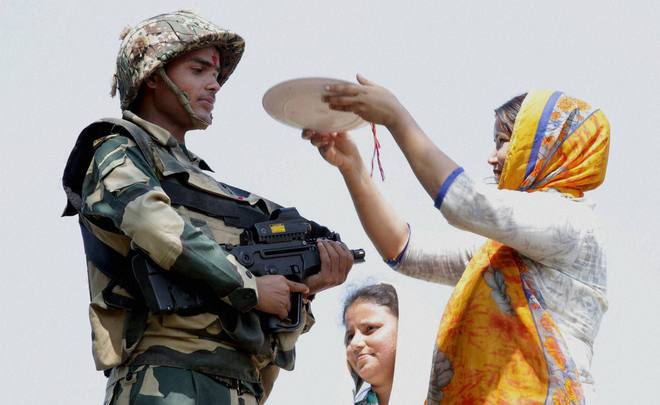 Girls tie Rakhi on the wrists of BSF jawans, near International Border RS Pura, in Jammu