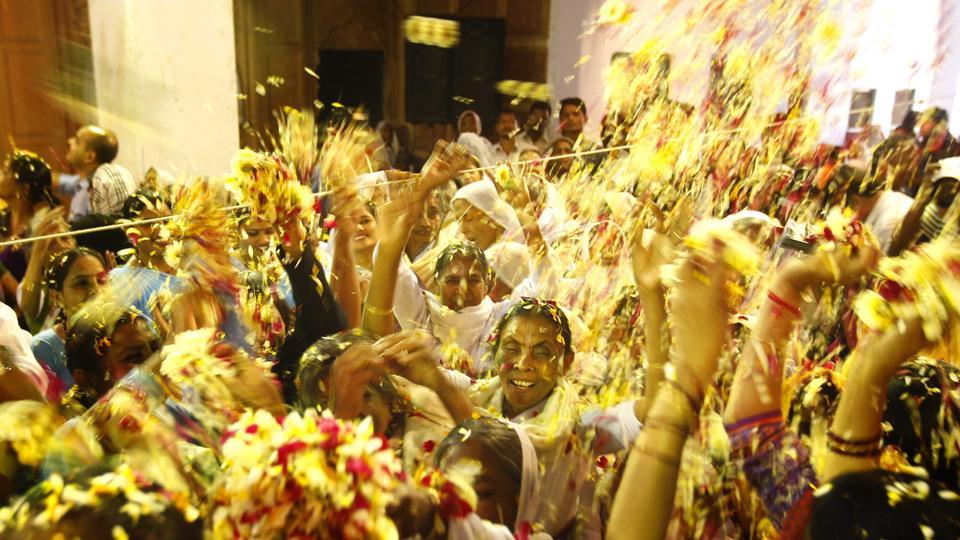 Hindu widows throw flower petals at each other as part of Holi celebrations organized by a NGO at Meera Sahbhagini Ashram in Vrindavan