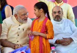 Prime Minister Narendra Modi interacts with a school girl who tied Rakhi to him on the occasion of Rakhabandhan festival, in New Delhi