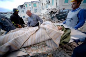 Rescuers carry a man from the rubble after a strong earthquake hit Amatrice, central Italy, on August 24, 2016. Central Italy was struck by a powerful 6.2-magnitude earthquake in the early hours.