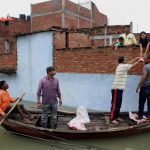 Rescuers distribute food in flooded-effected areas in a residential colony in Uttar Pradesh’s Allahabad on August 23, 2016