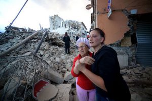Residents reacts among the rubble after a strong earthquake hit Amatrice, central Italy, on August 24, 2016. Central Italy was struck by a powerful 6.2-magnitude earthquake in the early hours.