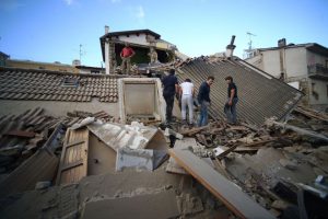 Residents walk among damaged homes after a strong earthquake hit Amatrice, central Italy, on August 24, 2016. Central Italy was struck by a powerful 6.2-magnitude earthquake in the early hours.
