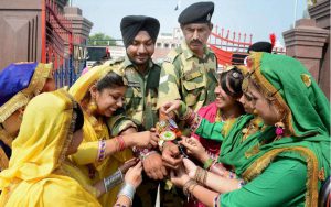 School girls, wearing traditional Punjabi dresses, tying Rakhi to BSF jawans on the occasion of Raksha Bandhan at the Attari-Wagah border