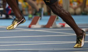 The gold coloured shoes of Usain Bolt are seen as he competes on his way to winning the gold medal.
