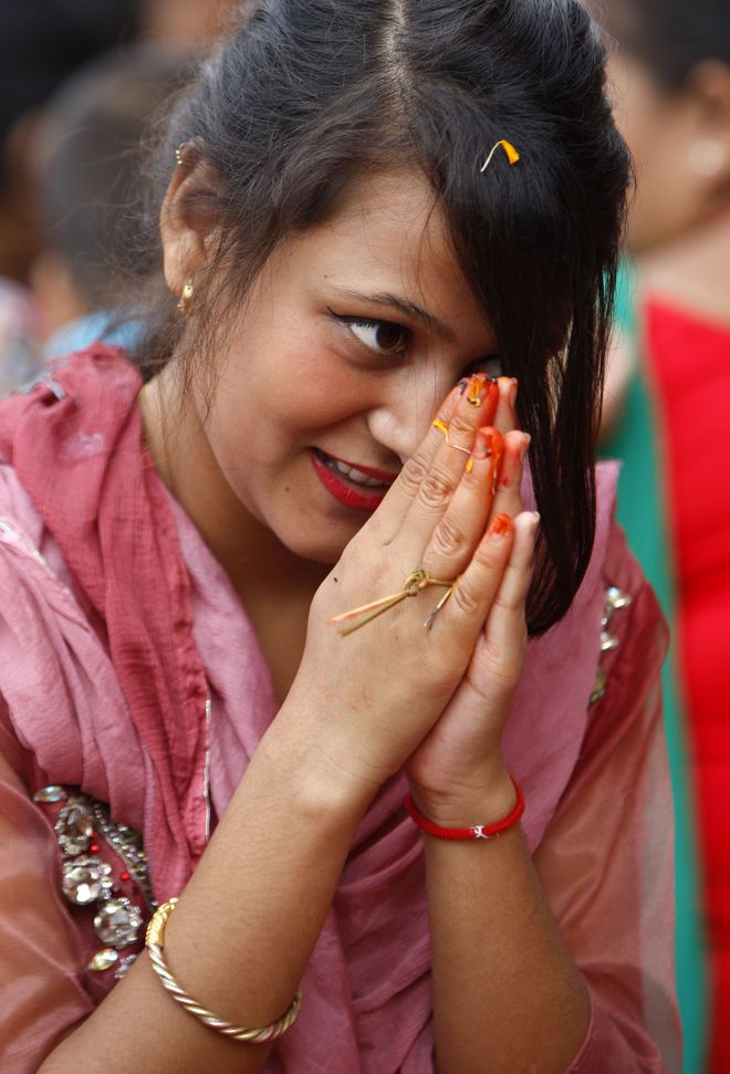 A Nepalese Hindu woman recites prayers led by a priest on the banks of the Bagmati River during the Rishi Panchami festival in Kathmandu on September 6.