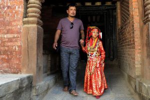 A Nepalese girl dressed as a Kumari, a living goddess, walks with a relative as she takes part in Kumari Puja rituals at the Hanuman Dhoka in Durbar Square in Kathmandu on September 14, 2016.