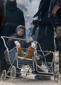 A child pushes a stroller while waiting with others to be evacuated from a rebel-held sector of eastern Aleppo, Syria, on December 16, 2016.
