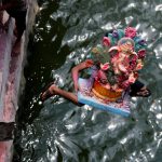 A devotee carrying an idol of the Hindu god Ganesh, the deity of prosperity, jumps into the Sabarmati River to immerse the idol on the last day of the Ganesh Chaturthi festival in Ahmedabad.