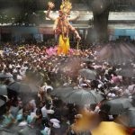 A huge idol of elephant-headed Hindu God Lord Ganesha is seen amidst a sea of devotees during its procession through heavy rain for an immersion in Mumbai.